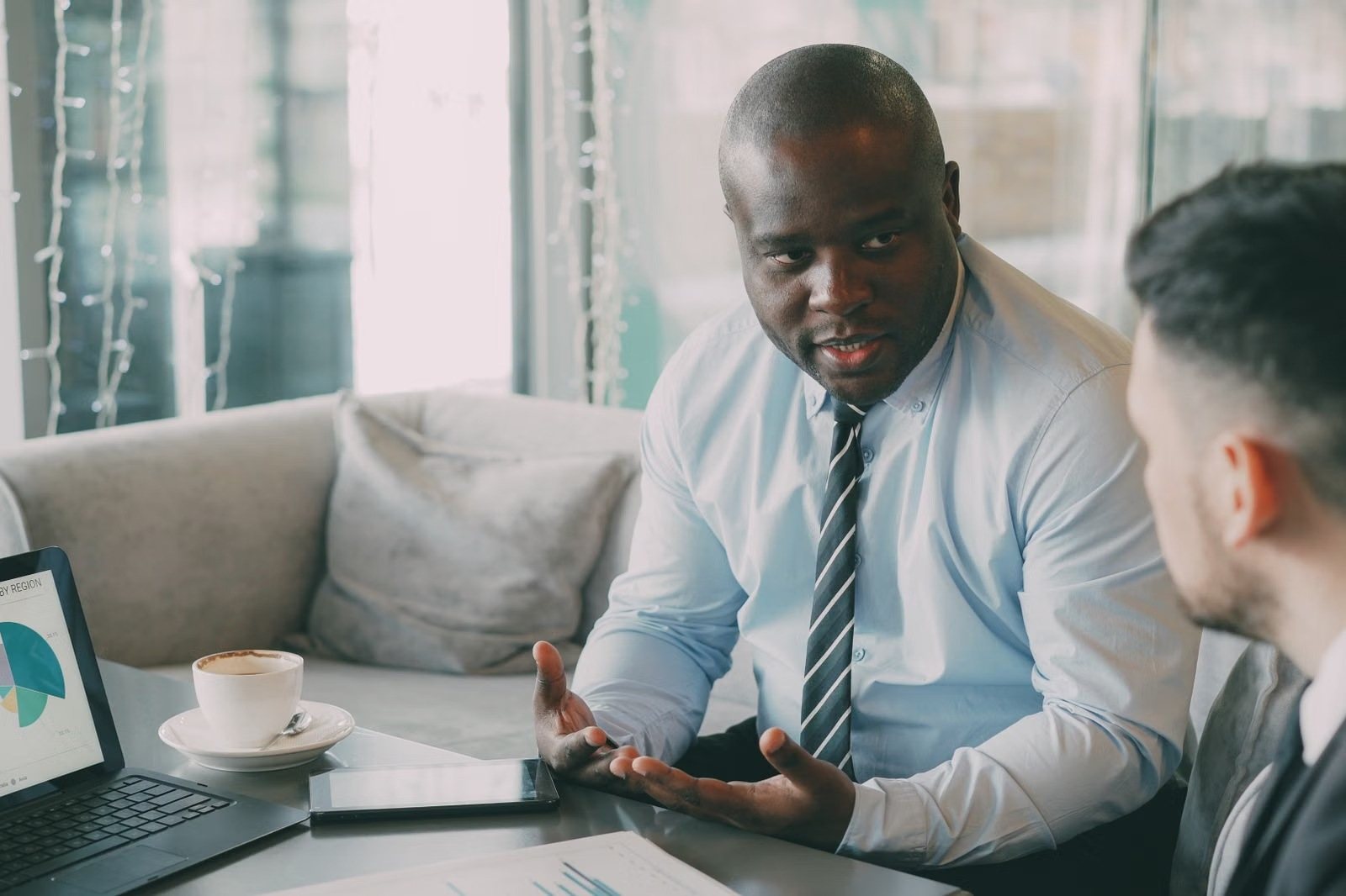 Financial expert talking with a client beside a laptop